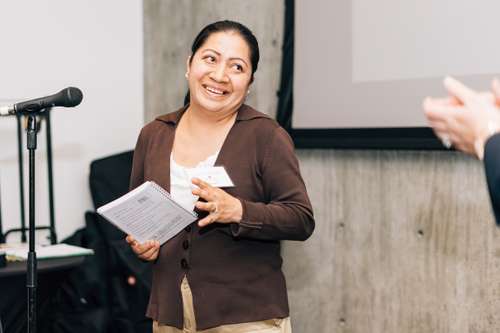 Learner reads to audience at Reading Between the Wines