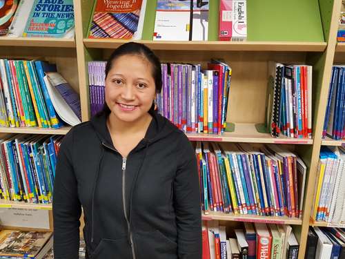 Rosa standing in front of books