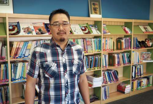 Sengs standing in front of bookshelf